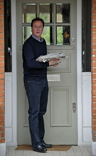 Party leaders on Sunday: David Cameron returns to his home, after leaving to buy newspapers