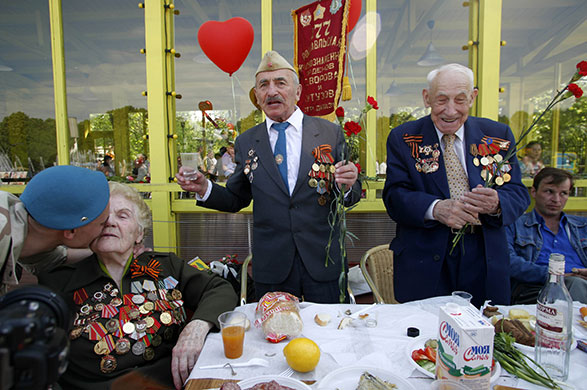 Victory day celebrations: A Russian army paratrooper, left, congratulates Second World War veterans