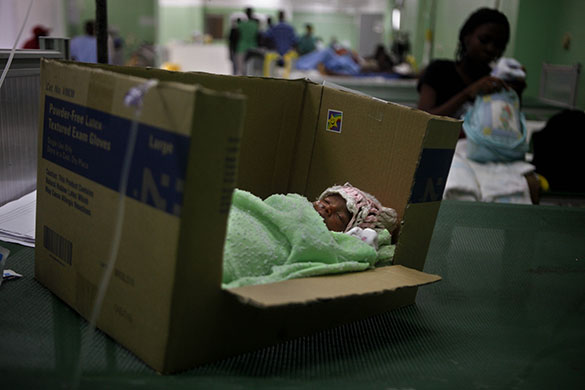 24 hours: Port-au-Prince, Haiti: Premature baby in a bed made out of a cardboard box