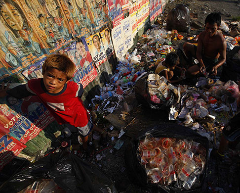 24 hours: Manila, Philippines: A family sorts through rubbish by election posters