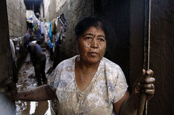 Guatemala storm: 30 May: A woman cleans mud from her home in Amatitilan