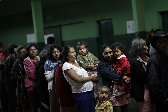 Guatemala storm: 30 May: People left homeless line up for food at a shelter in Amatitilan