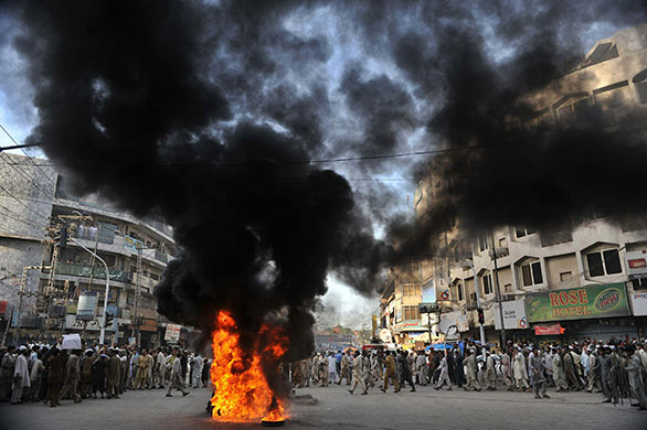 Israel protests: Pakistani demonstrators burn tyres during a protest in Peshawar 