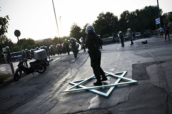 Israel protests: A policeman stands in a handmade Star of David in Athens