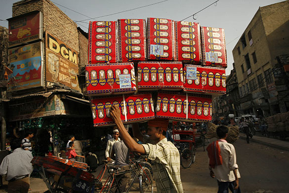 24 hours in pictures: New Delhi, India: A worker transports goods though a wholesale market