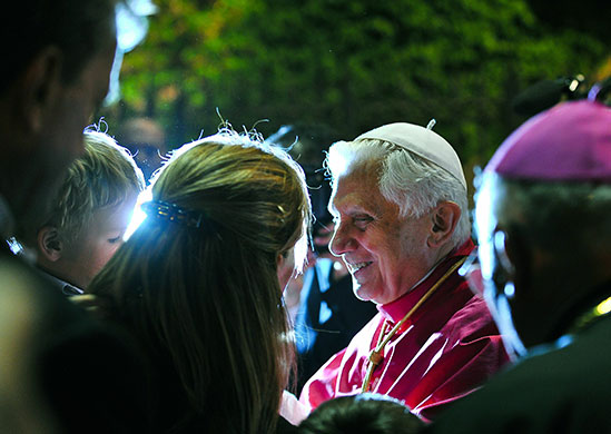 24 hours in pictures: Vatican City: Pope Benedict XVI smiles to a child