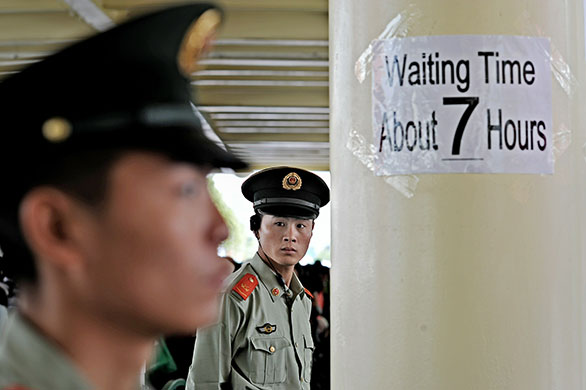 24 hours in pictures: Shanghai, China: Two PLA (People Liberation Army) personnel keep vigil