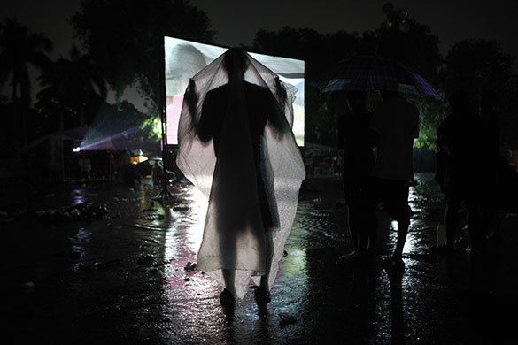 24 hours in pictures: Port-au-Prince, Haiti: A man protects himself from the rain