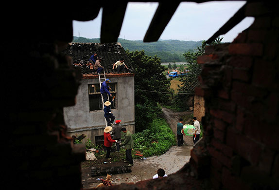 24 hours in pictures: Danjiangkou, China: Residents dismantle a house before relocation