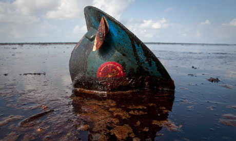 An oil worker's hard hat lies in oil from the Deepwater Horizon 
spill.