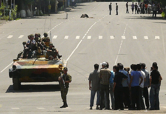 Kyrgyzstan violence: Soldiers sit on an armoured vehicle near a crowd on a street in Osh