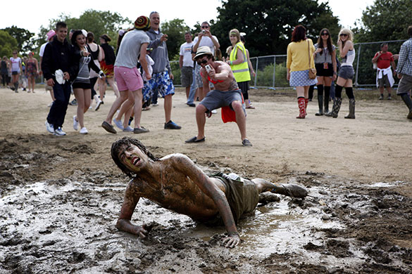 24 hours: Newport, UK:  A festival goer gets muddy at the Isle of Wight festival 2010
