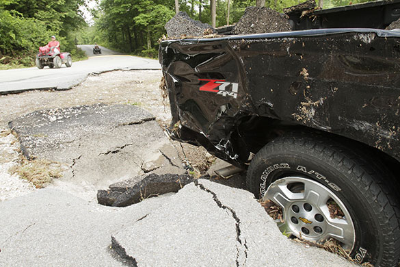 Arkansas floods: Search and rescue workers ride all terrain vehicles past a truck