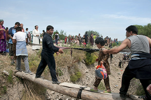 Kyrgyzstan violence: Ethnic Uzbeks cross the border from southern Kyrgyzstan into Uzbekistan