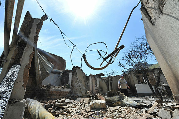 Kyrgyzstan violence: An Ethnik Uzbek man walks in the wreckage of his burned home in Osh