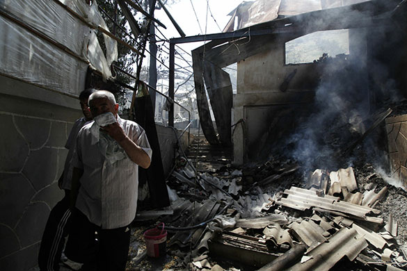 Kyrgyzstan violence: Ethnic Uzbeks walk beside the wreckage of burned houses in Osh