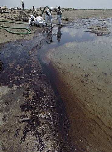 BP oil spill: Deepwater Horizon oil spill : Workers use a suction hose to remove oil