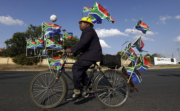 24 hours in pictures: Johannesburg, South Africa: A man rides a bicycle decorated with flags