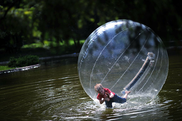 24 hours in pictures: Sofia, Bulgaria: A boy floats in an inflatable sphere at a lake