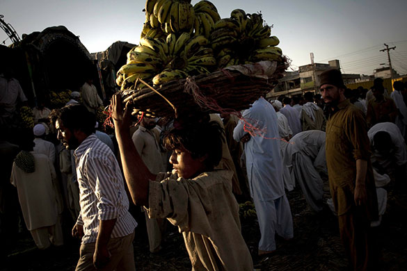 24 hours in pictures: Islamabad, Pakistan: A worker carries bananas at a fruit market