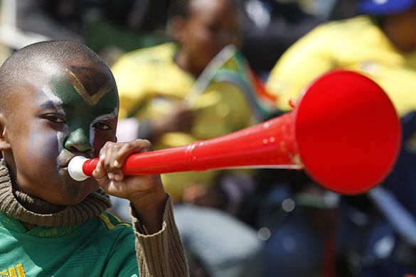 World Cup vuvuzelas: An African boy blows his vuvuzela 