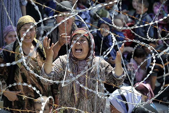 Uzbek refugees: A woman weeps as she stands in line in no-man's-land