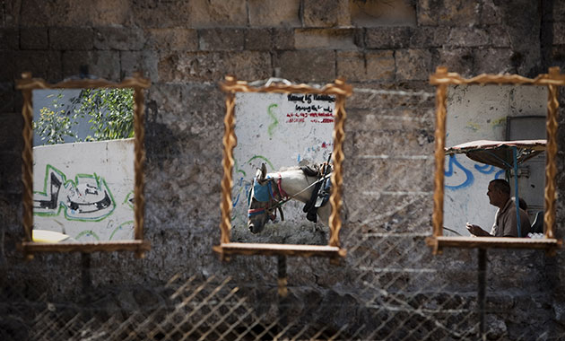 24 hours in pictures: A Palestinian man is reflected in a mirror as he rides a donkey 