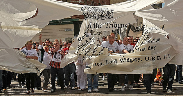 Bloody Sunday Inquiry: Crowds burst through a banner representing the Widgery Report