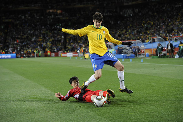Brazil versus North Korea: Kaka hurdles a sliding tackle from Mun In Guk