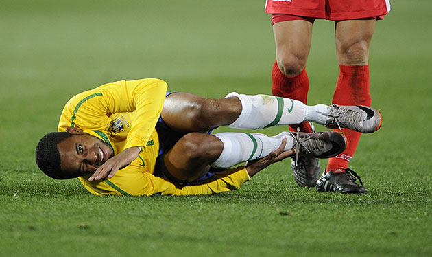 Brazil versus North Korea: Robinho goes down again clutching his ankle after a challenge