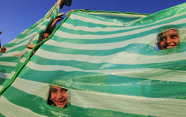 Summer Camp: Palestinian children peek through a fence