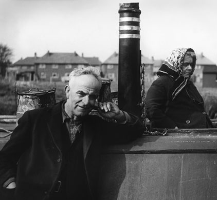 Longden's Canals: A man and his wife stand on their canal boat