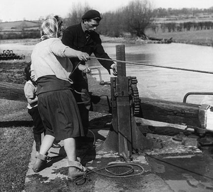 Longden's Canals: A family pull on the ropes of their boat as it moors