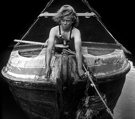 Longden's Canals: A girl looks at the camera as she lies on a canal boat