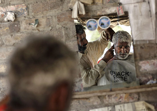 24 hours in pictures: Rawalpindi, Pakistan: A barber cuts the hair of a customer