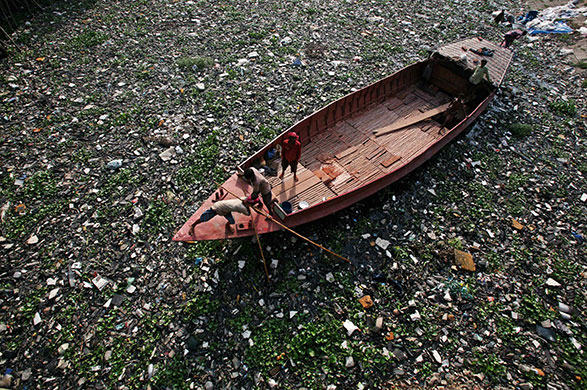 24 hours in pictures: Dhaka, Bangladesh: Boatmen row through polluted waters