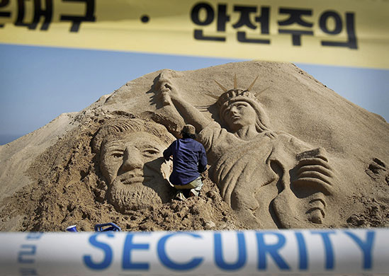 24 hours in pictures: Busan, South Korea: An artist works on a sand sculpture