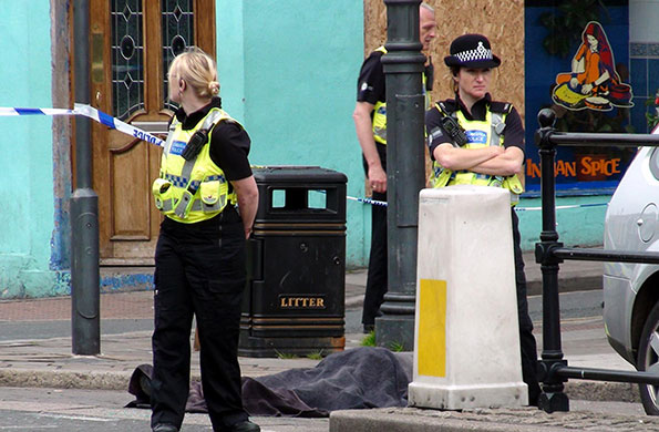 Cumbria shootings: Police stand next to the body of Darren Rewcastle on Duke Street, Whitehaven. Rewcastle, a fellow taxi driver, was Bird's first victim