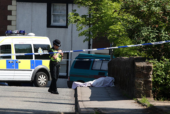 Cumbria shootings: The body of a local man lies under a blanket on a bridge in the market town of Egremont, five miles south of Whitehaven