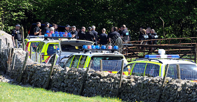 Whitehaven shootings: Police officers stand in a wooded area close to Derrick Bird's car