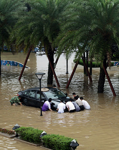 Chian flooding: Chinese residents gather help remove a car as flood waters rise in Guilin