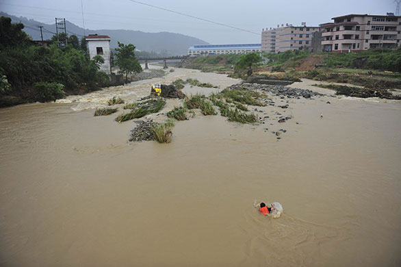 Chian flooding: A rescuer swims to a bus submerged by the flash floods in Nanping