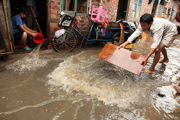 Chian flooding: People drain the street in a residential community  in Nanning