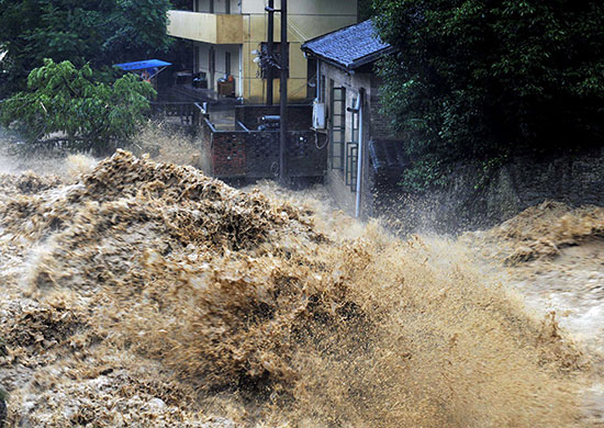 Chian flooding: Flood water roars past houses in the Xiqin township