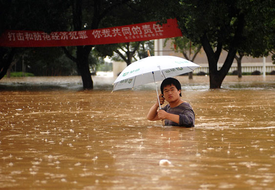 China flooding 2: A man wades through the waterlogged street in Yujiang county