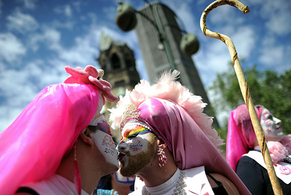 24 hours in pictures: Two participants of the Christopher Street Day gay pride parade kiss