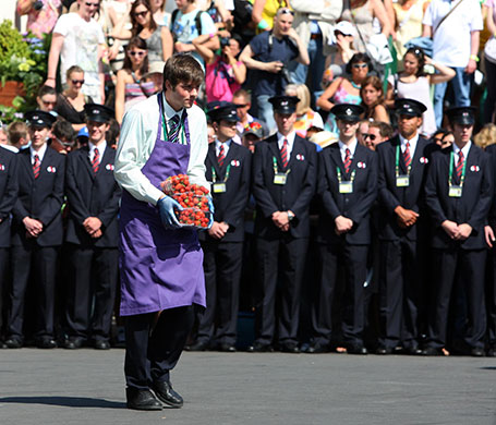 Wimbledon day one: A worker carries strawberries