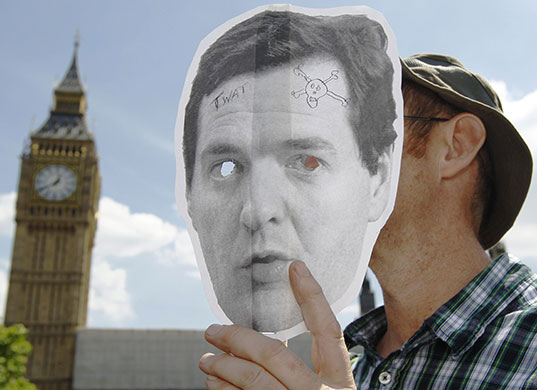 budget day: A demonstrator holds up a mask of the Chancellor 