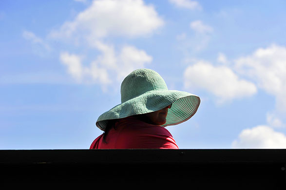 wimbledon atmosphere: A spectator wearing a hat in the hot sun