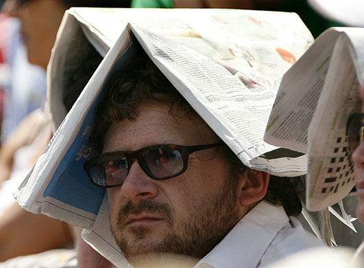 wimbledon atmosphere: Spectators use the Guardian to shelter from the sun 